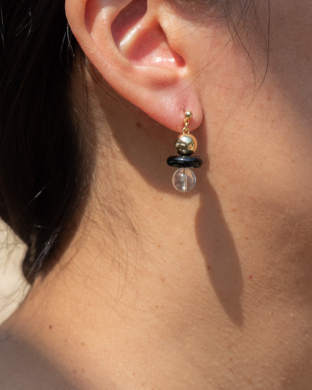 Elegant Stella earrings with 14k gold vermeil ball, onyx and clear quartz, exuding a sophisticated style perfect for any occasion.