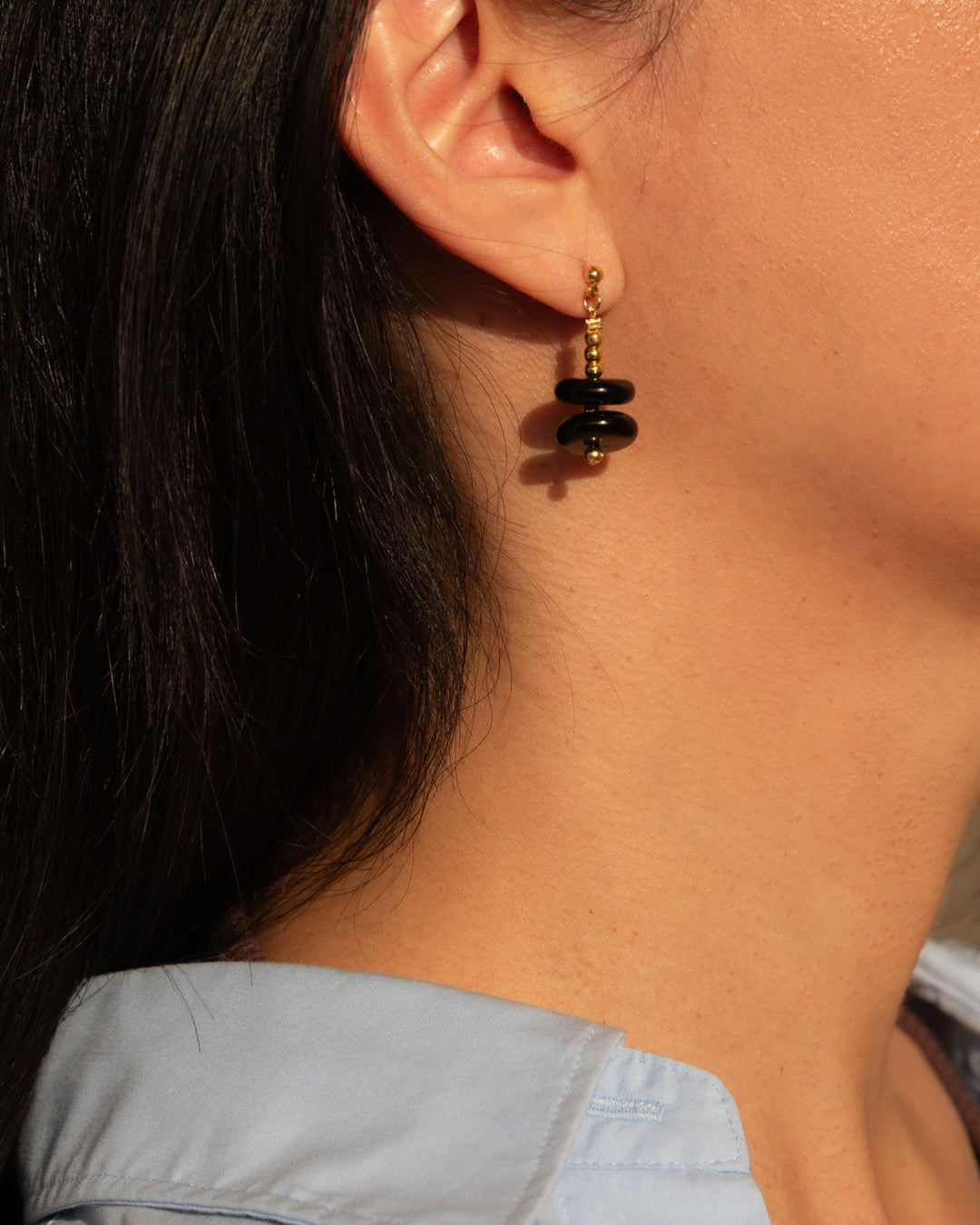 Dusk earrings of onyx and 14k gold vermeil on model, showcasing its elegance and modernness.