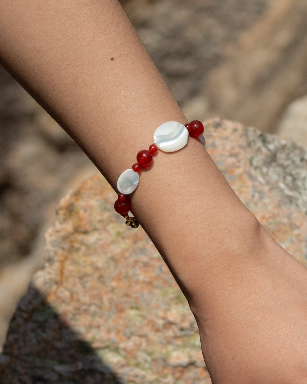 Red Sonata Moonlit Bracelet featuring red agate and mother of pearl (MOP) beads, handcrafted for casual elegance, accessorizing with a pop of color and natural charm.