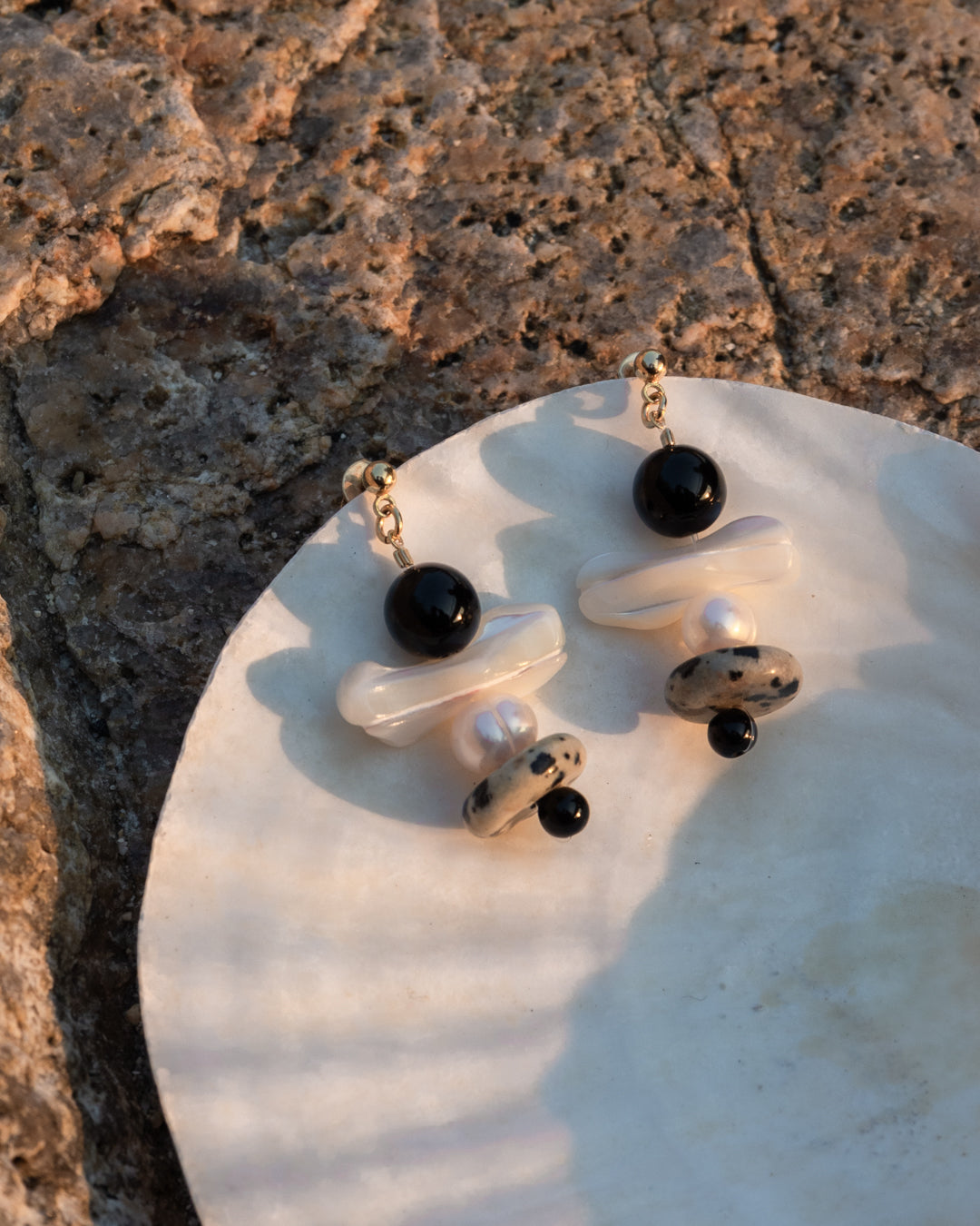 Tulip earrings: Mother of pearl and freshwater pearl dangle earrings, set of two, set on the shell of a mother-of-pearl on the beach.