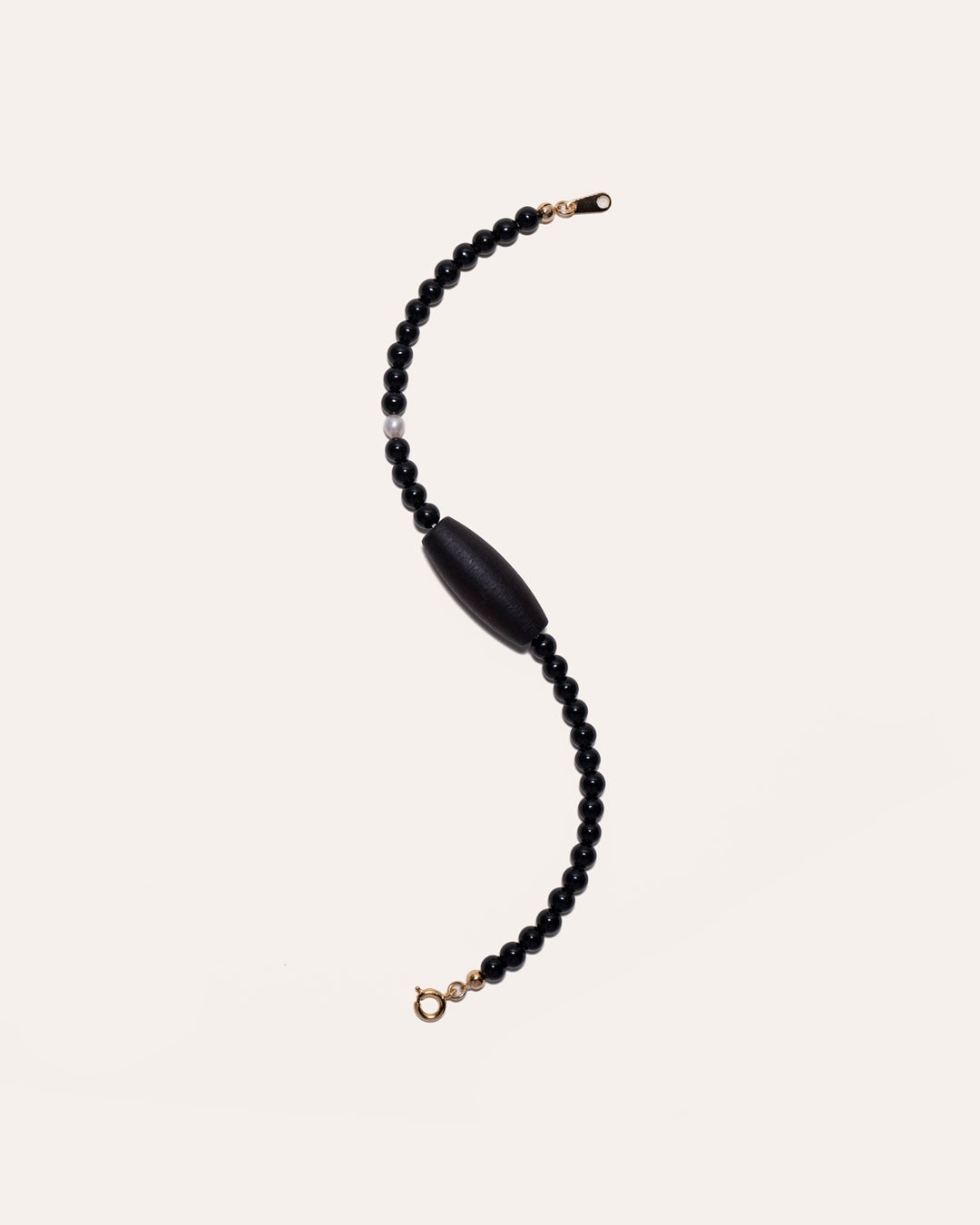 Gem & One Rooted bracelet with oval dark rosewood bead, black onyx, and freshwater pearl.