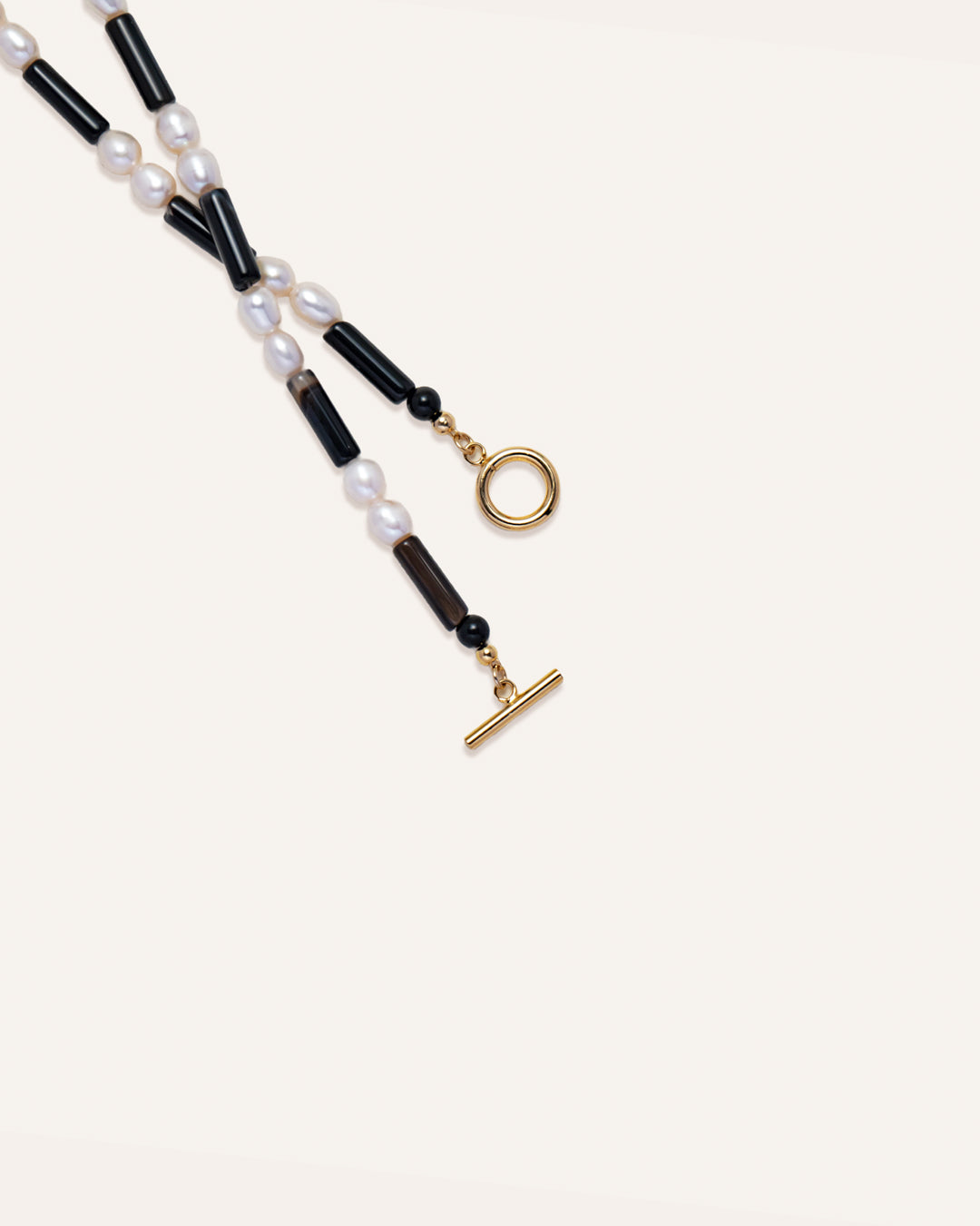 Rhythm necklace featuring freshwater pearls and onyx keys, designed for style and individuality. 