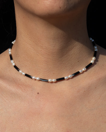 Rhythm Necklace in Onyx featuring freshwater pearls. Designed to accentuate style and fashion. This statement piece adds a touch of elegance to any outfit. Made with high-quality materials, the necklace is perfect for everyday wear or special occasions. The black onyx complements the natural sheen of the pearls, creating a striking contrast. Purchase now to elevate your look! 