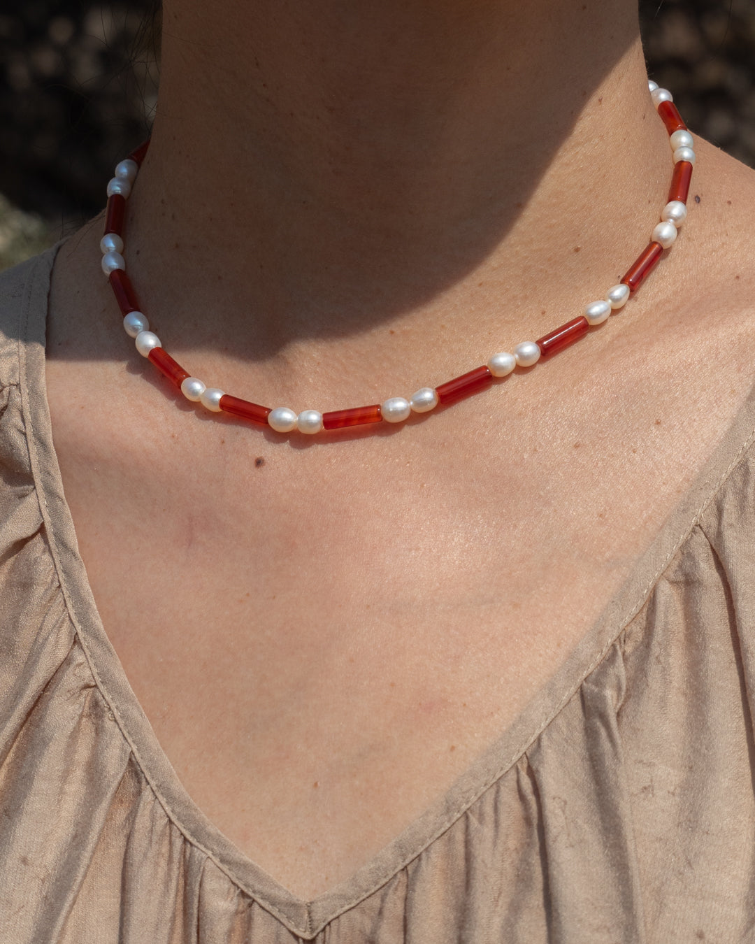 Elegant Rhythm Necklace in red agate with freshwater pearls, showcasing vibrant colors and natural beauty.
