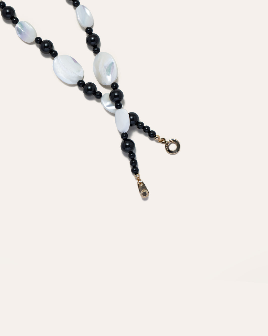 Mother of pearl and onyx beaded Sonata Moonlit necklace, elegantly showcasing its design and craftsmanship against a neutral background. 
