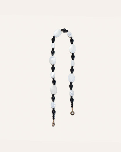 Sonata Moonlit Necklace, a striking combination of mother of pearl (MOP) and onyx gemstones. The necklace features a beaded design that intertwines with the natural luster of MOP stones and the contrasting dark hue of onyx stones. This elegant necklace is perfect for both formal and casual occasions, bringing a touch of sophistication to any outfit. 