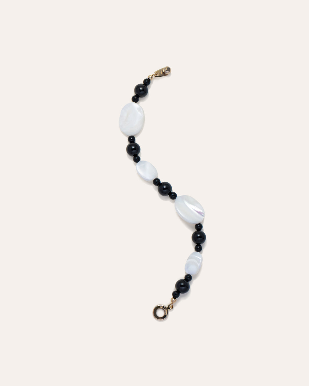 Sonata Moonlit Bracelet: Elegant Onyx and Mother of Pearl (MOP) Jewelry, laid flat in a s-shape. Fashion Accessory for Women, Handcrafted Design.