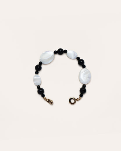 Sonata Moonlit Onyx Bracelet - Chic accessory featuring onyx stones and delicate mother of pearl inlay, set against a pink black background. A timeless piece that adds a touch of elegance to your daily style. 